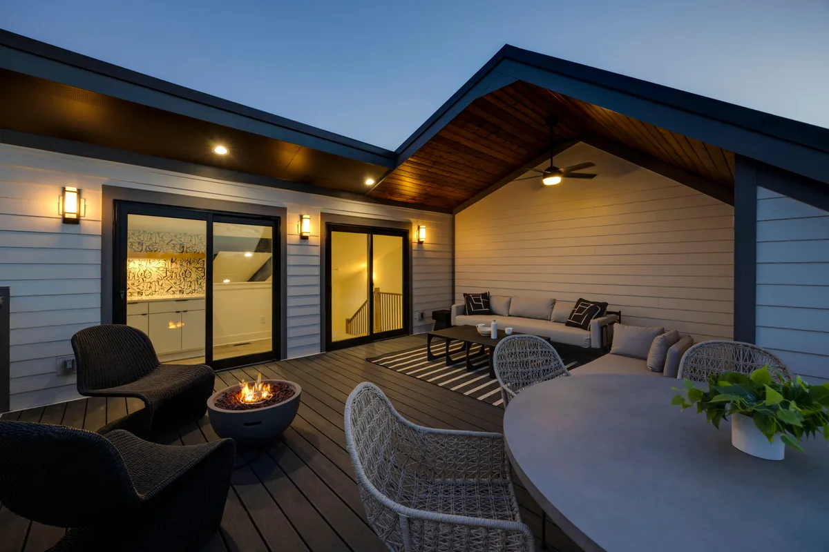 The hero image showcases the exterior of a modern, luxurious single-family home in Nashville, featuring a cozy fire pit surrounded by elegant seating, warm outdoor lighting, and expansive sliding glass doors that invite guests between indoor and outdoor spaces. The inviting setup is ideal for evening gatherings, relaxed conversations, and enjoying Nashville nights under the stars.